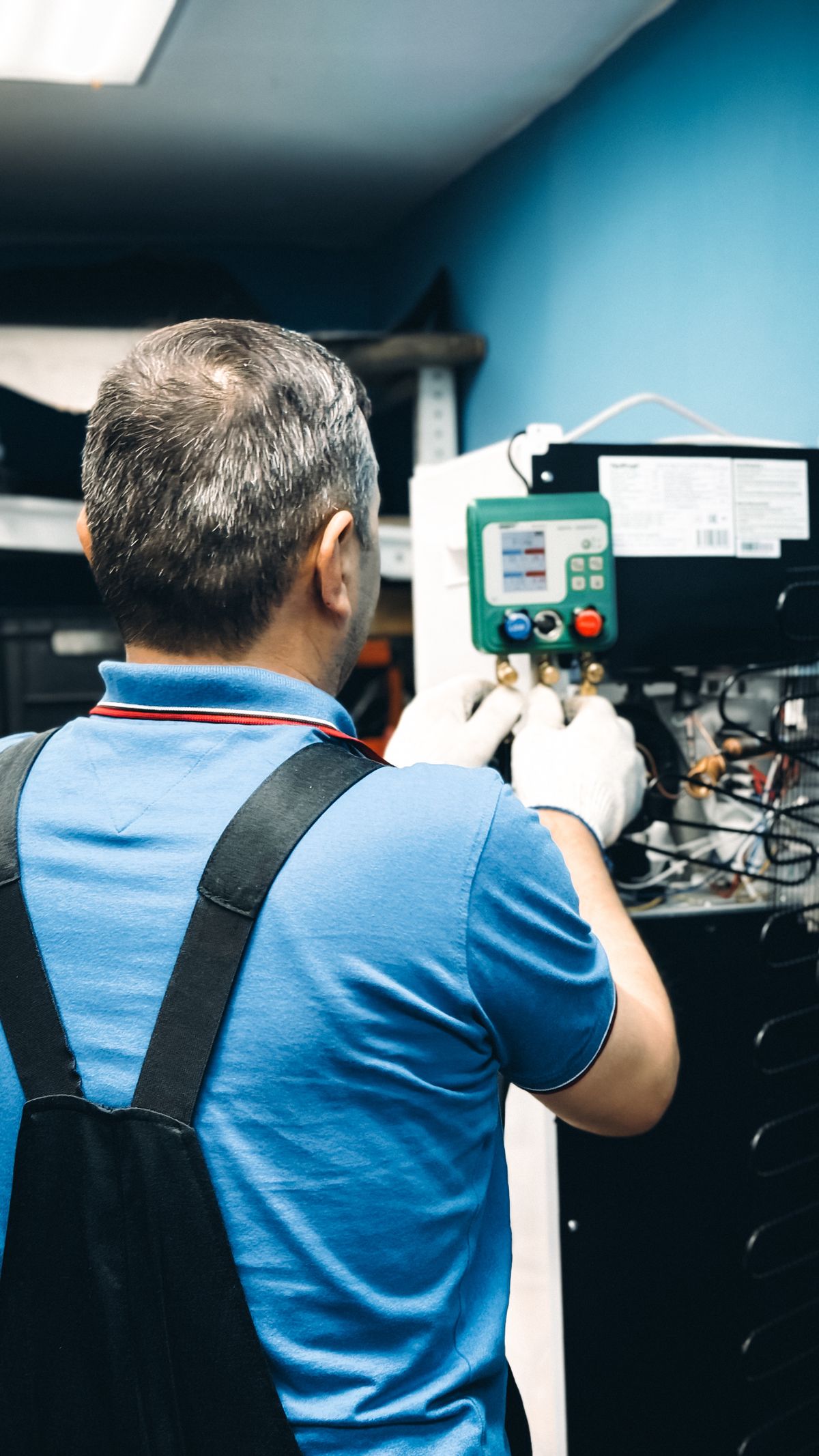 A technician servicing a residential heating system in a utility room.